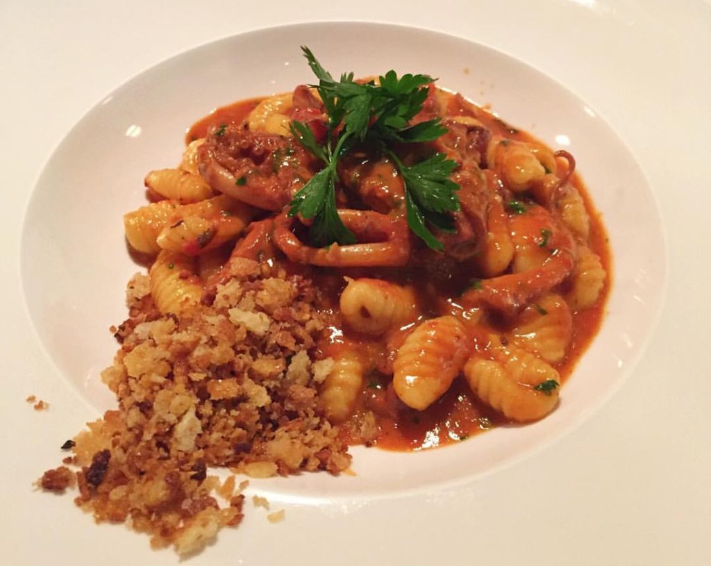 Cavatelli all’arrabbiata with octopus and fresh tomatoes, a spicy seafood pasta dish combining Molise tradition with Mediterranean flavor.