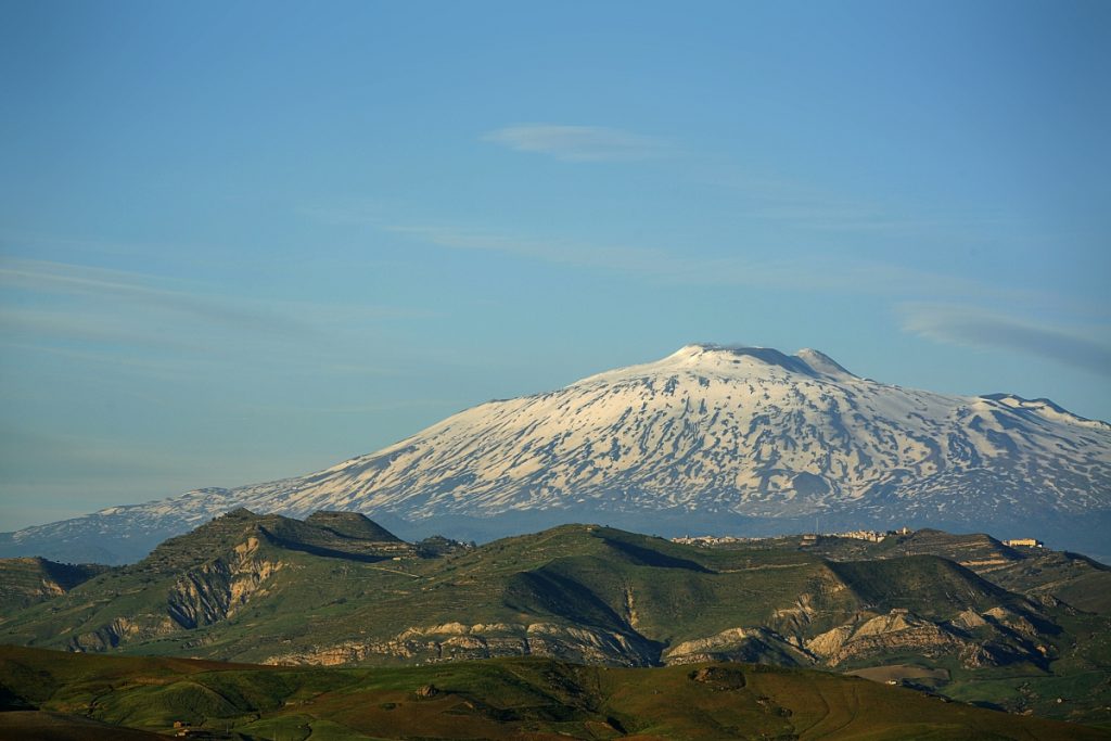 Panoramic view of Mount Etna with its snowy summit and surrounding landscape