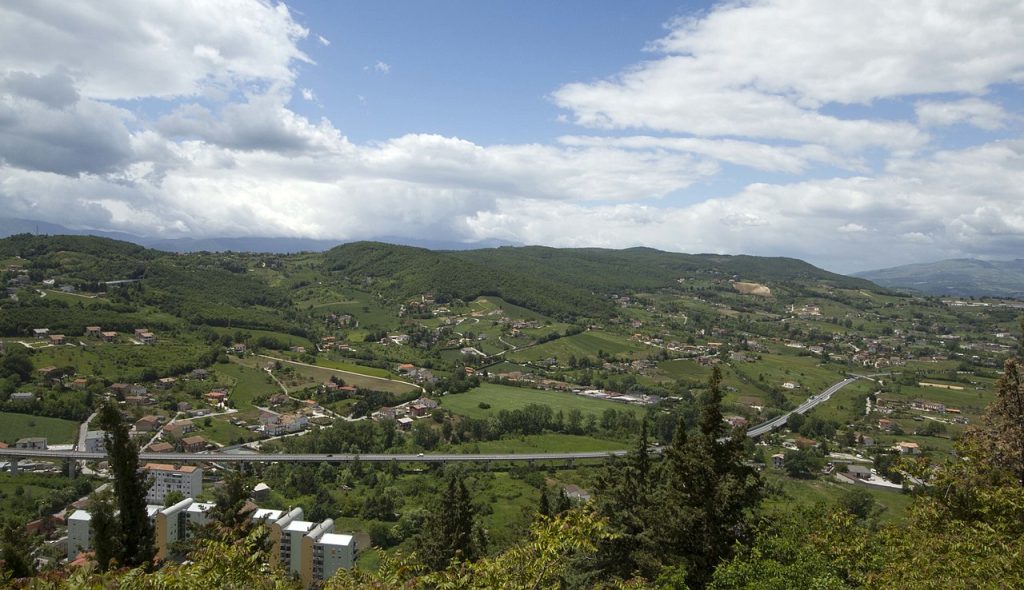 Old Town of Campobasso, Italy, surrounded by green countryside and rolling hills with patches of grass.