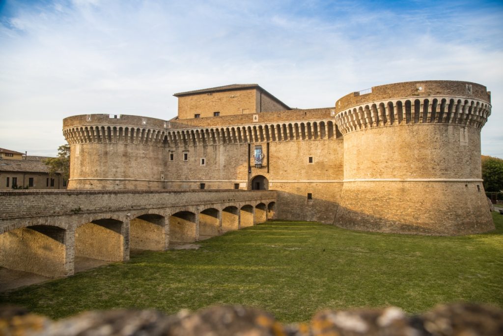The imposing Rocca Roveresca fortress in Senigallia, showcasing its sturdy stone walls and battlements under a clear blue sky.