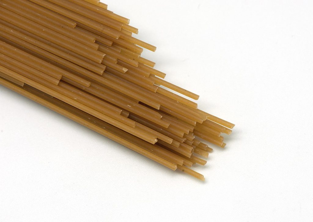 Bigoli pasta closeup on a white background