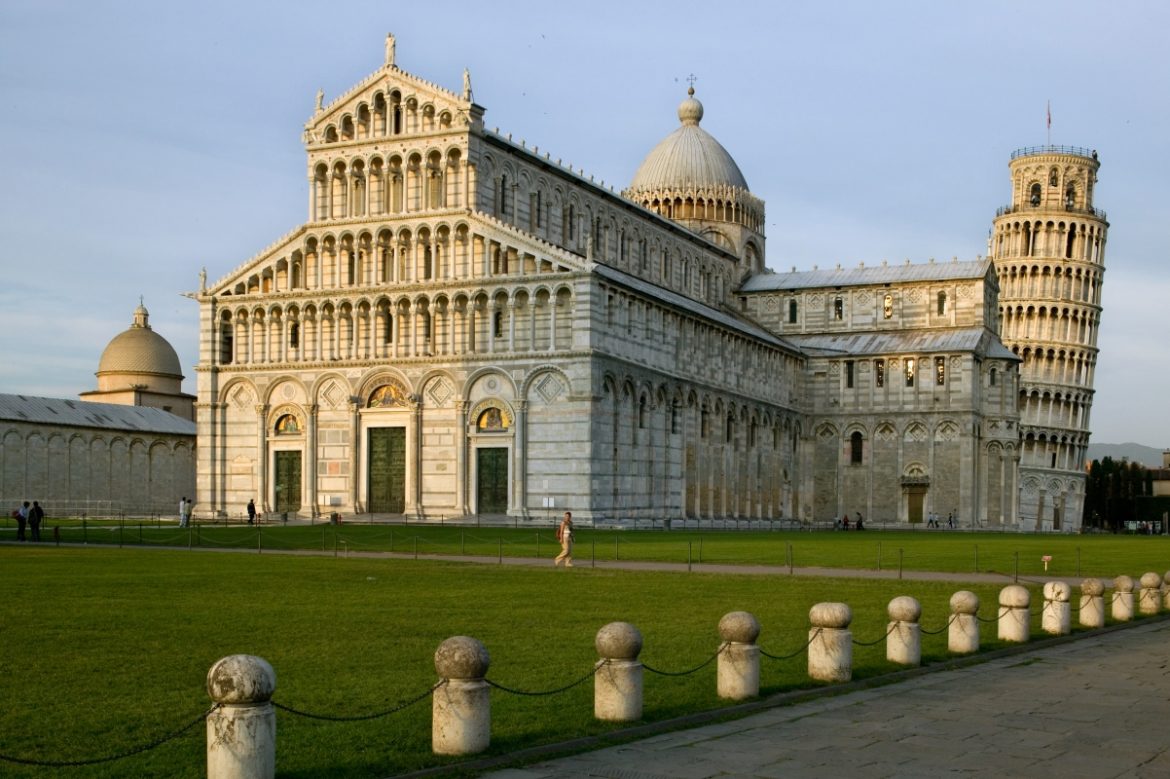 Leaning Tower and Pisa Cathedral with clear blue sky in Piazza dei Miracoli showcasing as to why the Pisa Tower is leaning