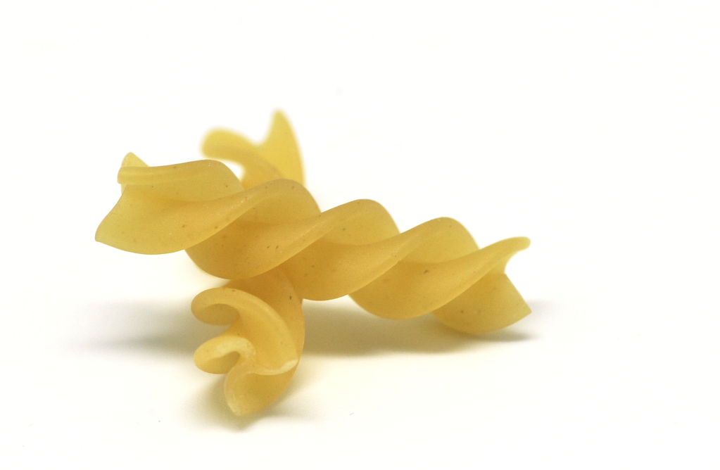 Italian pasta shapes guide: Fusilli pasta closeup on a white background