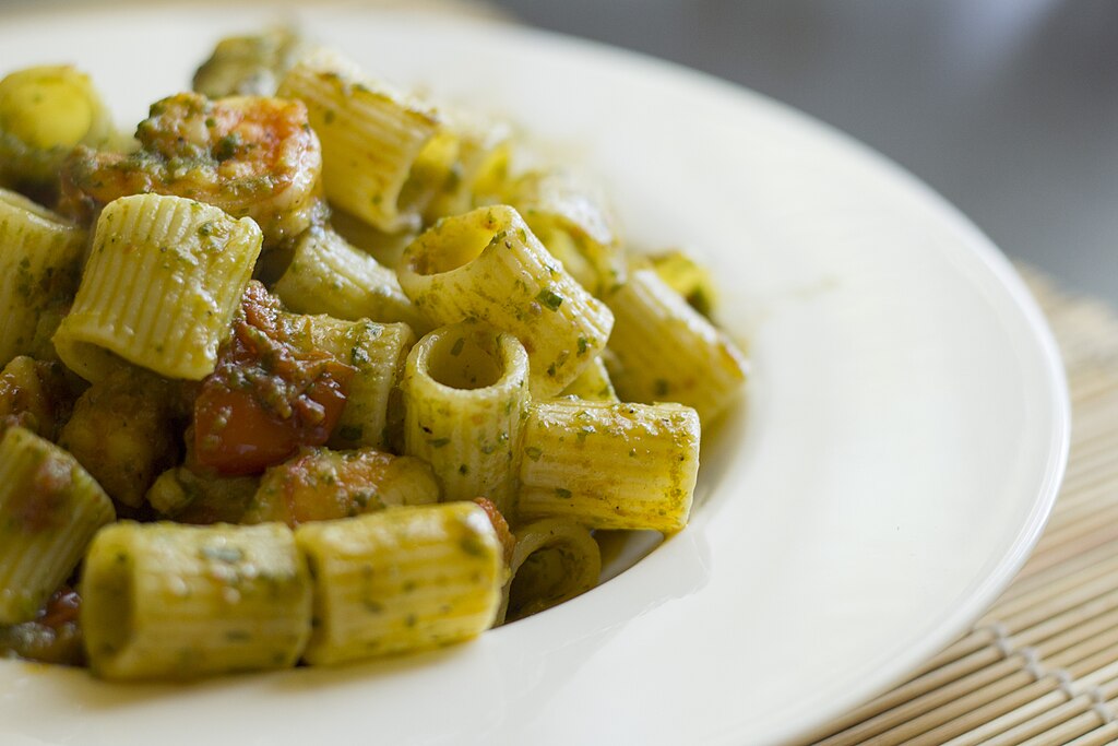 A dish of pasta with pesto and shrimps showcasing Italian pasta shapes guide for seafood recipes