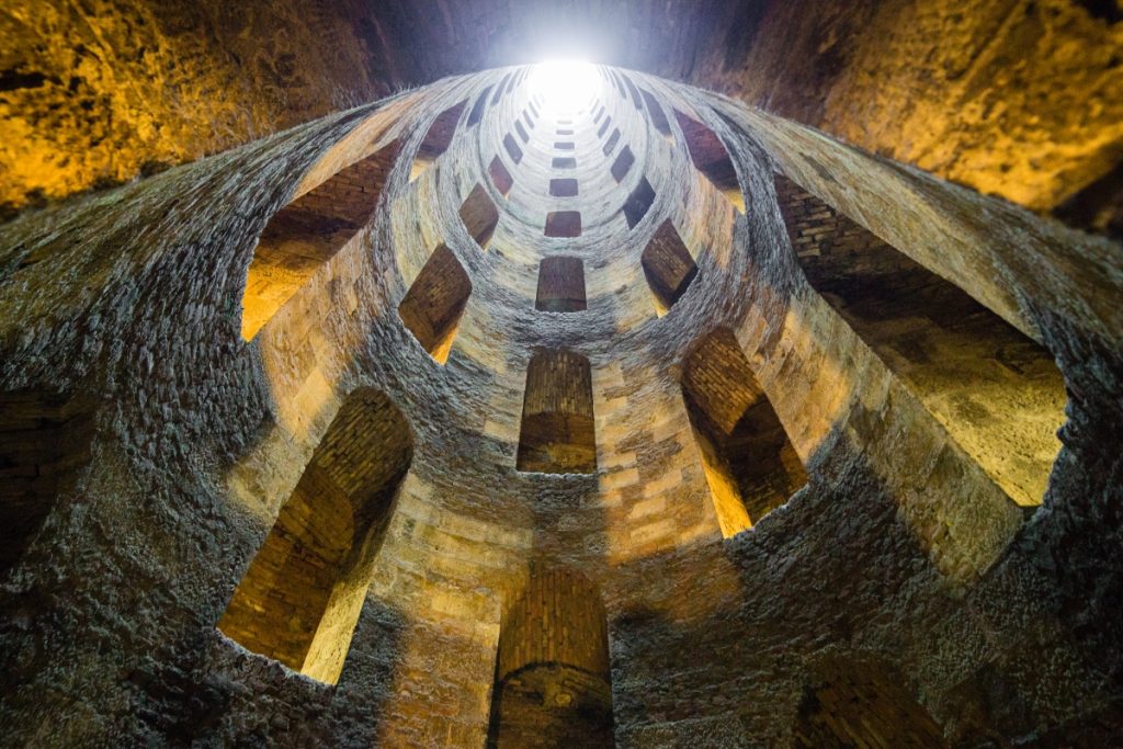 Interior view of Pozzo di San Patrizio in Orvieto showcasing the spiral staircase that embodies the architectural wonders encountered on a journey through Umbria.