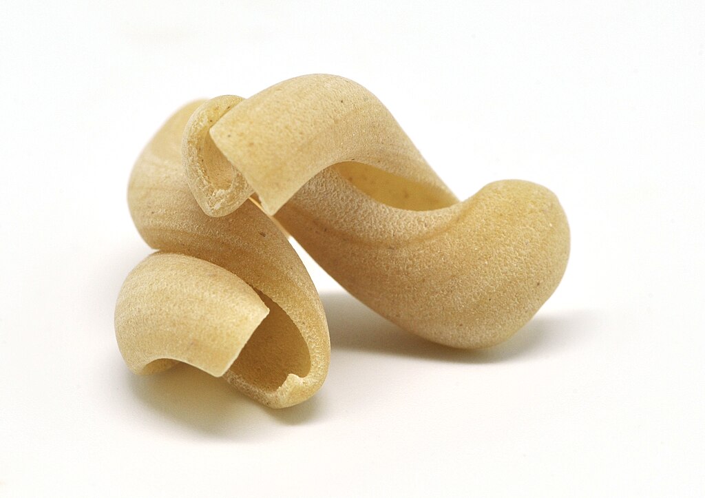 Strozzapretti pasta closeup on a white background