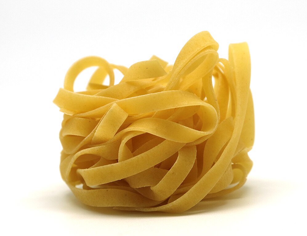 Tagliatelle pasta closeup on a white background